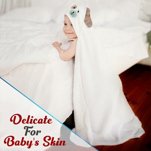 Smiling baby in a soft hooded towel, delicate for baby's skin.