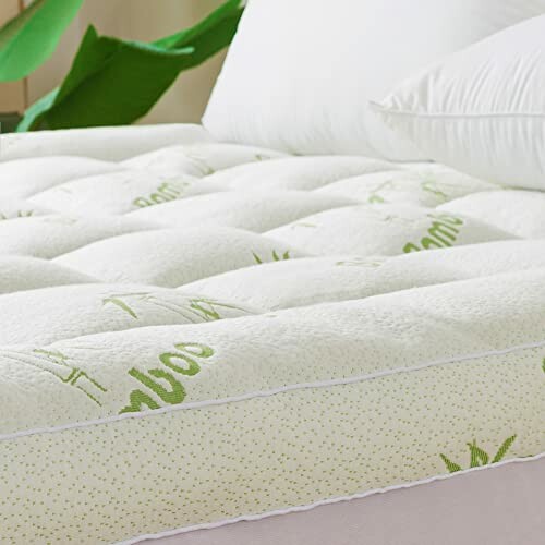 Close-up of a bamboo fiber mattress topper on a bed with a pillow.