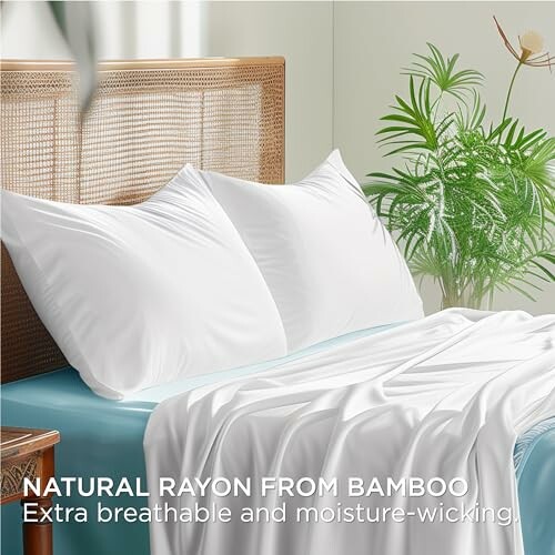 White bamboo rayon bedding set on a bed with pillows and a plant nearby.