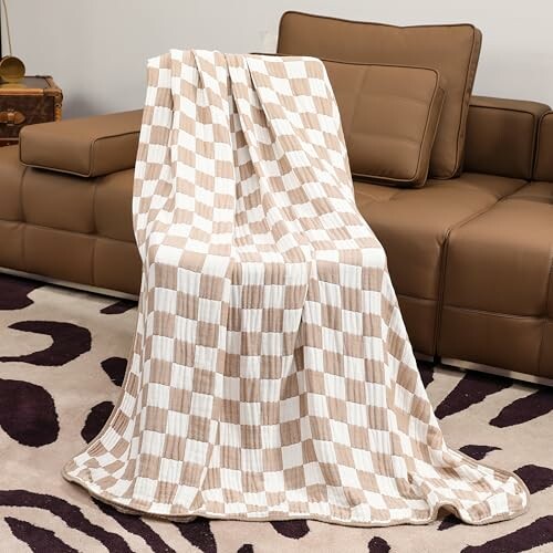 Checkered blanket draped over a brown sofa.