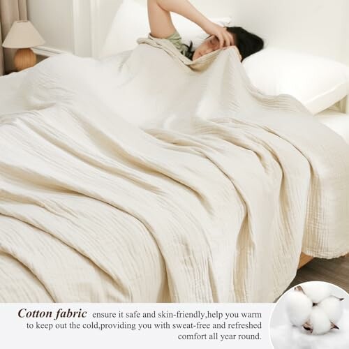 Person lying under a soft cotton fabric comforter in a bed.