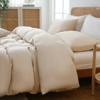 Cozy bedroom with neutral-colored bedding and pillows.