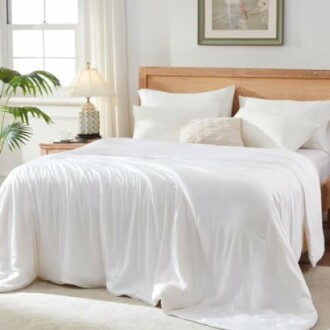 A cozy bedroom with white bedding and a wooden bed frame.