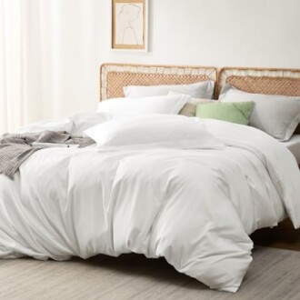 A neatly made bed with white bedding and decorative pillows.