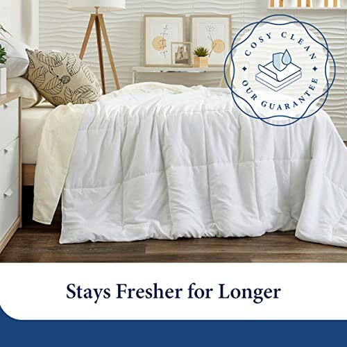 White comforter on bed with cozy clean guarantee.