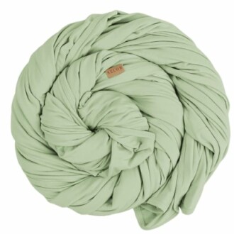 A green baby wrap blanket rolled up in a swirl shape.