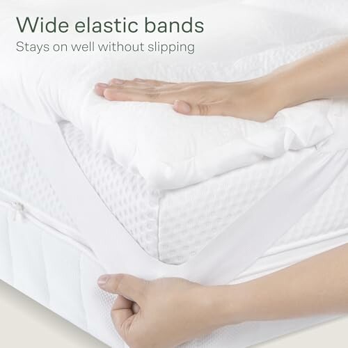 Hands adjusting mattress cover with wide elastic bands.