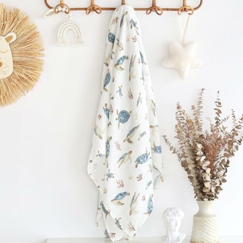 Nursery wall with hanging fabric, decorative items, and a vase.