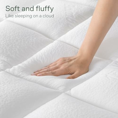 Hand pressing soft, fluffy mattress surface.