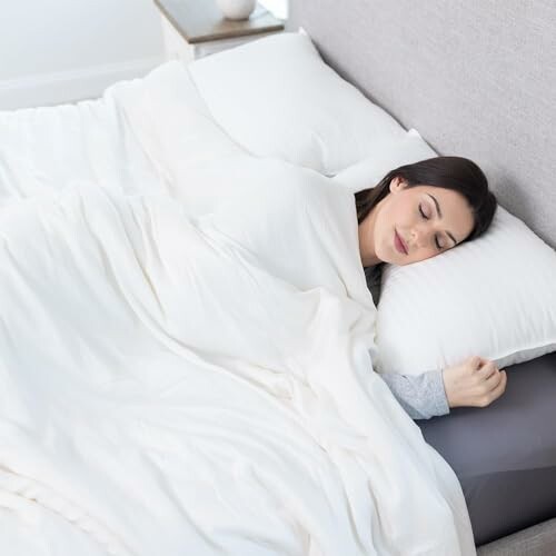 Woman sleeping peacefully in bed with white bedding.