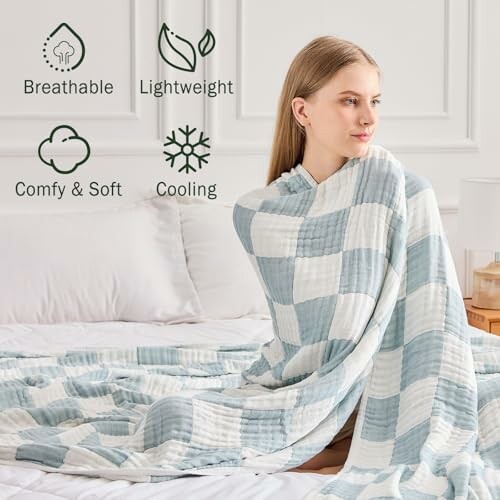 Woman wrapped in a blue and white checkered blanket, with icons labeled breathable, lightweight, comfy & soft, cooling.